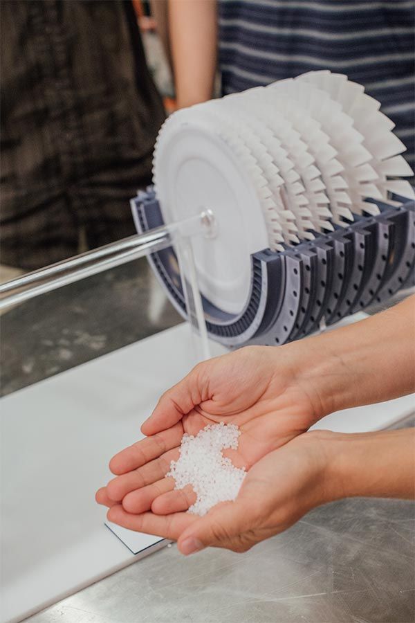 A Malta prototype in background with hands holding salt in the foreground.