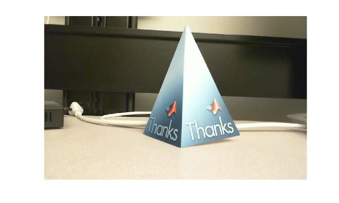 Snapshot from the Jetson board showing a blue card on a desk. The card has an image of an L-shaped membrane and the word "Thanks" printed on it.